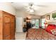 Main bedroom with king bed, red bedding, and access to bathroom at 2509 Gables Dr, Eustis, FL 32726