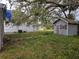 Backyard view shows an overgrown area with two older outbuildings with weathering at 1105 S Locust Ave, Sanford, FL 32771