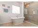 Bright bathroom features free-standing soaking tub, tiled shower, and large window at 1989 Marsh Hen Vlg, Deland, FL 32720