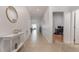 Hallway features neutral tile flooring with decor including a gold mirror and white console table at 1989 Marsh Hen Vlg, Deland, FL 32720