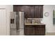 Kitchen with stainless steel appliances, dark wood cabinets, granite countertops, and tile backsplash at 1989 Marsh Hen Vlg, Deland, FL 32720