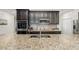 Detailed view of the kitchen island with granite countertops, a sink, and dark wood cabinets at 1989 Marsh Hen Vlg, Deland, FL 32720