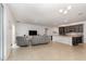 Open-concept living room featuring tile floors, gray sofas, and a view of the kitchen with dark wood cabinets at 1989 Marsh Hen Vlg, Deland, FL 32720