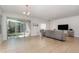 Bright living room with neutral tile flooring, a gray sofa set, and access to a screened lanai at 1989 Marsh Hen Vlg, Deland, FL 32720