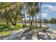 Scenic river view with walking path, benches, and palm trees at 1989 Marsh Hen Vlg, Deland, FL 32720