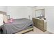 Well-lit bedroom with gray bedding and dresser at 2582 Glacier Express Ln, Tavares, FL 32778