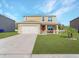 Two-story house with attached garage and well-maintained lawn at 2582 Glacier Express Ln, Tavares, FL 32778