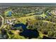 Aerial view of the community showcasing a golf course, lakes and mature trees at 943 Elm Harbor Ct, Lake Mary, FL 32746