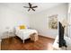 Cozy bedroom with hardwood floors, a ceiling fan, and a window with natural light at 943 Elm Harbor Ct, Lake Mary, FL 32746