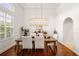 Bright dining room featuring a wooden table, stylish light fixture, and plantation shutters at 943 Elm Harbor Ct, Lake Mary, FL 32746