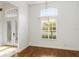 Bright, high-ceilinged entryway featuring hardwood floors, a modern light fixture and shuttered windows at 943 Elm Harbor Ct, Lake Mary, FL 32746