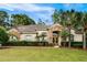 Charming one-story home showcasing a manicured front lawn, stone accents, and mature palm trees at 943 Elm Harbor Ct, Lake Mary, FL 32746