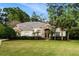 Beautiful home with a lush green lawn, mature trees, and a charming stone and stucco facade at 943 Elm Harbor Ct, Lake Mary, FL 32746