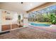 Spacious lanai with brick pavers and a view of the living room and screened-in pool at 943 Elm Harbor Ct, Lake Mary, FL 32746