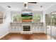 Bright living area with stone fireplace, built-in cabinets and view of the patio at 943 Elm Harbor Ct, Lake Mary, FL 32746