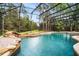Screened in pool with a waterfall feature and lovely backyard view at 943 Elm Harbor Ct, Lake Mary, FL 32746