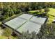Aerial view of two well-maintained tennis courts surrounded by lush greenery at 943 Elm Harbor Ct, Lake Mary, FL 32746
