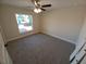 Bedroom features neutral-toned walls and carpet with a ceiling fan and window at 8749 Se 159Th Ln, Summerfield, FL 34491