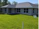 Well-maintained single-story home featuring a covered porch and expansive backyard, creating an inviting outdoor space at 8749 Se 159Th Ln, Summerfield, FL 34491