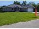 Charming single-story home featuring a lush green lawn and attached two-car garage, ideal for Gathering living at 8749 Se 159Th Ln, Summerfield, FL 34491