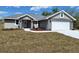 Charming single-Gathering home features a two-car garage, manicured lawn, and stylish gray paint at 8749 Se 159Th Ln, Summerfield, FL 34491
