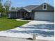 Beautifully landscaped single-story house with a spacious driveway and manicured lawn, perfect for suburban living at 8749 Se 159Th Ln, Summerfield, FL 34491