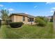 Well-maintained lawn with shrubbery and a screened-in lanai, creating an inviting backyard at 5307 Cortland Dr, Davenport, FL 33837