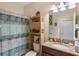 Bathroom with granite counters and a blue shower curtain at 5307 Cortland Dr, Davenport, FL 33837