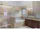 Elegant bathroom with a glass-enclosed shower, soaking tub, and granite countertop vanity, offering a luxurious spa-like experience at 5307 Cortland Dr, Davenport, FL 33837