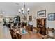 Formal dining room with a dark wood table and chairs, complemented by a stylish chandelier and an open view to the kitchen at 5307 Cortland Dr, Davenport, FL 33837