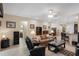 Spacious living room featuring tile floors, a leather sofa, and an open layout flowing into the kitchen area at 5307 Cortland Dr, Davenport, FL 33837