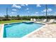 Inviting backyard pool and spa surrounded by lush landscaping and a paved patio on a sunny day at 7763 Westland Dr, Kissimmee, FL 34747