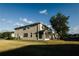Rear exterior of home featuring green space and manicured lawn at 13910 Dove Wing Ct, Orlando, FL 32828