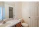 Cozy half bathroom featuring a vanity with a sink, a toilet, and a large mirror at 13910 Dove Wing Ct, Orlando, FL 32828
