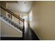 Inviting hallway with hardwood floors, a staircase with wooden railings, and neutral-colored walls at 13910 Dove Wing Ct, Orlando, FL 32828