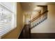 Bright hallway with hardwood floors, a staircase with wooden railings, and a large window with blinds at 13910 Dove Wing Ct, Orlando, FL 32828