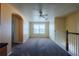 Open loft space featuring carpeted floor, window, and archway entrance at 13910 Dove Wing Ct, Orlando, FL 32828