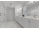 Bright bathroom featuring double sinks, white marble tile flooring, and a glass-enclosed shower at 11218 Pixie Mandarin Ct, Winter Garden, FL 34787