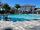 A view of the community pool with lounge chairs, umbrellas and a building in the background at 11218 Pixie Mandarin Ct, Winter Garden, FL 34787