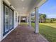 Covered patio with brick flooring, showcasing ample space and access to the backyard and nearby community pool at 11218 Pixie Mandarin Ct, Winter Garden, FL 34787