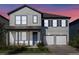 Two-story home featuring a two-car garage, blue front door, and manicured landscaping at 11218 Pixie Mandarin Ct, Winter Garden, FL 34787