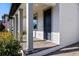 Inviting front porch with grey pillars, brick flooring, and a dark blue front door at 11218 Pixie Mandarin Ct, Winter Garden, FL 34787