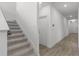 Hallway with carpeted stairs and tile flooring, leading to a closed door at 11218 Pixie Mandarin Ct, Winter Garden, FL 34787