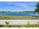 Picturesque pond view featuring clear blue waters, lush greenery, and an inviting sidewalk at 11218 Pixie Mandarin Ct, Winter Garden, FL 34787