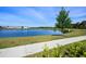 Scenic view of the serene pond with lush landscaping, trees, and a tranquil walking path at 11218 Pixie Mandarin Ct, Winter Garden, FL 34787