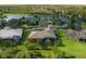 Aerial view of homes in the neighborhood featuring mature trees, manicured lawns, and a serene lake at 1221 Glendora N Rd, Kissimmee, FL 34759