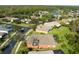 Aerial view showcasing a well-maintained neighborhood with mature trees, landscaping, and a serene lake at 1221 Glendora N Rd, Kissimmee, FL 34759