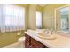 Well-lit bathroom with a white vanity, ample counter space, and a large mirror reflecting natural light at 1221 Glendora N Rd, Kissimmee, FL 34759