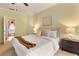 Neutral bedroom with a Queen bed, two side tables and lamps, and an adjoining bathroom at 1221 Glendora N Rd, Kissimmee, FL 34759