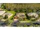 Aerial view showing a terracotta home with screened in pool, surrounded by lush greenery and neighborhood at 1221 Glendora N Rd, Kissimmee, FL 34759